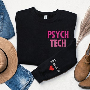 May include: Black sweatshirt with the words "PSYCH TECH" in pink lettering on the front and the name "Bonnie" with a red heart on the sleeve.