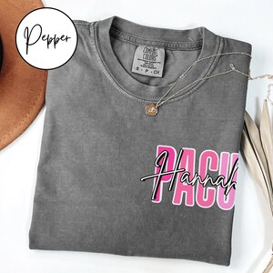 May include: Gray t-shirt with a pink and white graphic that says "PACU Hannah".