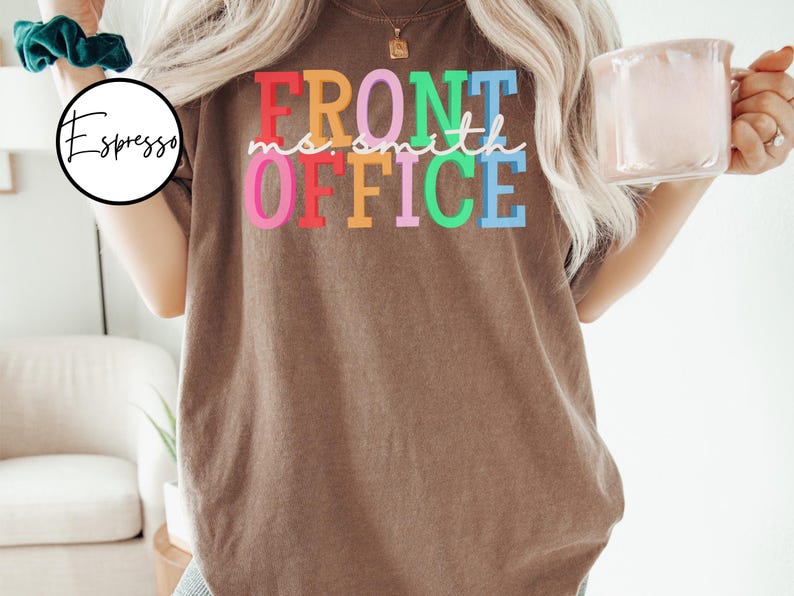Pu&ograve; includere: Una maglietta marrone con il testo "Front Office" in colori arcobaleno. Il testo &egrave; in un font divertente e casual.