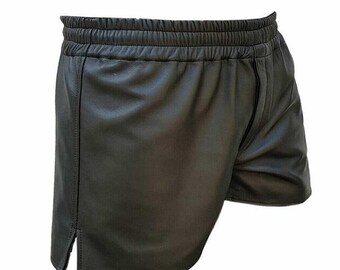 May include: Black leather shorts with an elastic waistband and side slits. The shorts have a relaxed fit and a smooth, matte finish. The design is simple and modern, suitable for various casual outfits.