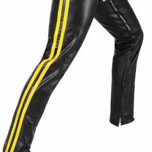 May include: Black leather pants with two vertical yellow stripes down the side of the leg. The pants have a zipper detail on the lower leg. The material appears to be shiny.