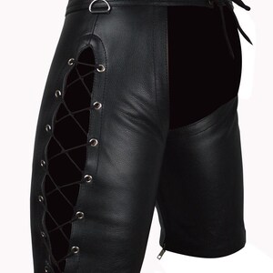 May include: Black leather shorts with lace-up detailing on the sides. The shorts feature a high waist, a D-ring, and a zipper closure. The design includes a solid black panel on the back.