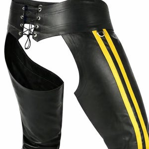 May include: Black leather chaps with yellow stripes down the sides. The chaps feature a lace-up waist and are designed to be worn over other clothing. The overall design is sleek and edgy.