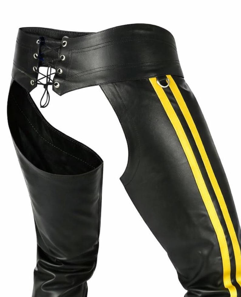 May include: Black leather chaps with yellow stripes down the sides. The chaps feature a lace-up waist and are designed to be worn over other clothing. The overall design is sleek and edgy.