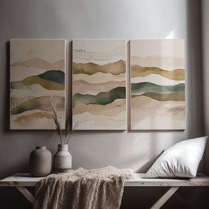 Puede incluir: Tres pinturas abstractas de paisajes en tonos apagados de marrón, beige y verde. Las pinturas están enmarcadas en blanco y colgadas en una pared gris.