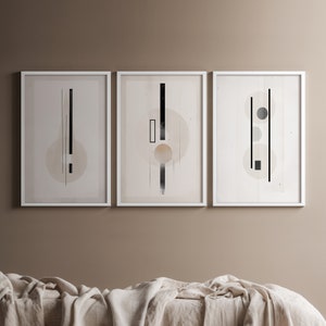 Puede incluir: Tres impresiones de arte abstracto enmarcadas en blanco con formas geométricas en blanco y negro sobre un fondo beige.