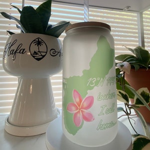 Vaso de vidrio esmerilado con mapa de Guam y una plumeria rosa