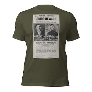 May include: Olive green t-shirt featuring a vintage police notice with the text "£1000 REWARD WANTED FOR MURDER IN IRELAND." The notice includes portraits and text in English and Gaelic, with the name "DANIEL BREEN" prominently displayed.