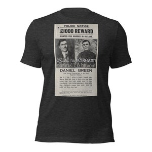 May include: Dark gray t-shirt featuring a vintage police notice with the text "£1000 REWARD WANTED FOR MURDER IN IRELAND." The notice includes portraits and details about Daniel Breen, a Commandant of the Third Tipperary Brigade.