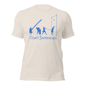May include: A white t-shirt with a blue silhouette of people playing a game of hurling. The text "Clúicí Sàeveaslacas" is printed below the image.