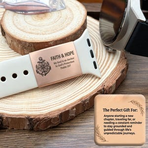 May include: A white silicone watch band featuring a rose gold metal charm engraved with an anchor, a compass, and the text FAITH & HOPE, My Soul is an Anchor, In God's Protection, Psalm 107, alongside a square wooden card with printed text.
