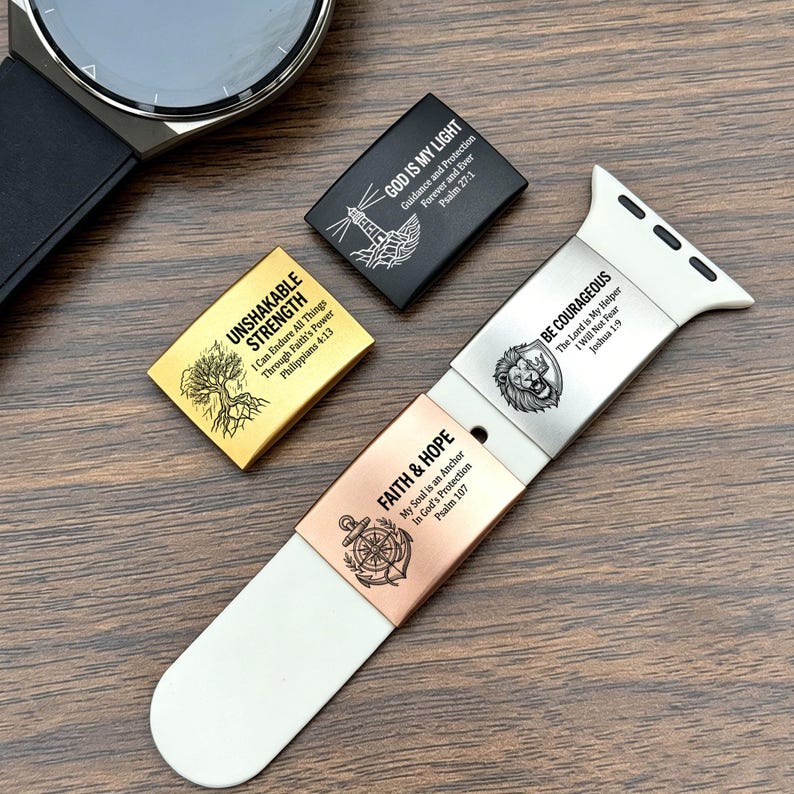 May include: A white silicone watch band featuring two metallic sliders engraved with "BE COURAGEOUS" and "FAITH & HOPE" with anchor and lion motifs. Two additional loose metallic sliders are included, one gold with "UNSHAKABLE STRENGTH" and one black with "GOD IS MY LIGHT".