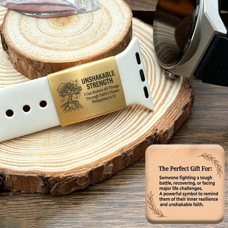 May include: A white silicone watch band featuring a gold-toned metal charm engraved with a tree illustration and the text UNSHAKABLE STRENGTH I Can Endure All Things Through Faith's Power Philippians 4:13, positioned on a round wood slice.