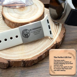 May include: A white silicone watch band featuring a metallic silver-toned slider engraved with a lion head, a shield, and the text BE COURAGEOUS, The Lord is My Helper, I Will Not Fear, Joshua 1:9, alongside a square card with printed text.