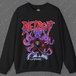 May include: Black sweatshirt with a graphic print of a red hooded figure wielding a hockey stick, battling a purple octopus with flames. The text "DETROIT" is printed in red above the graphic.