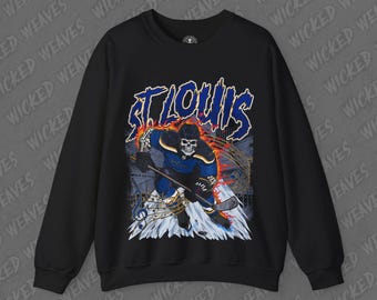 May include: Black sweatshirt with a graphic print of a skeleton hockey player in a blue and white uniform with flames and musical notes. The text "ST. LOUIS" is printed in a bold, white font above the graphic.