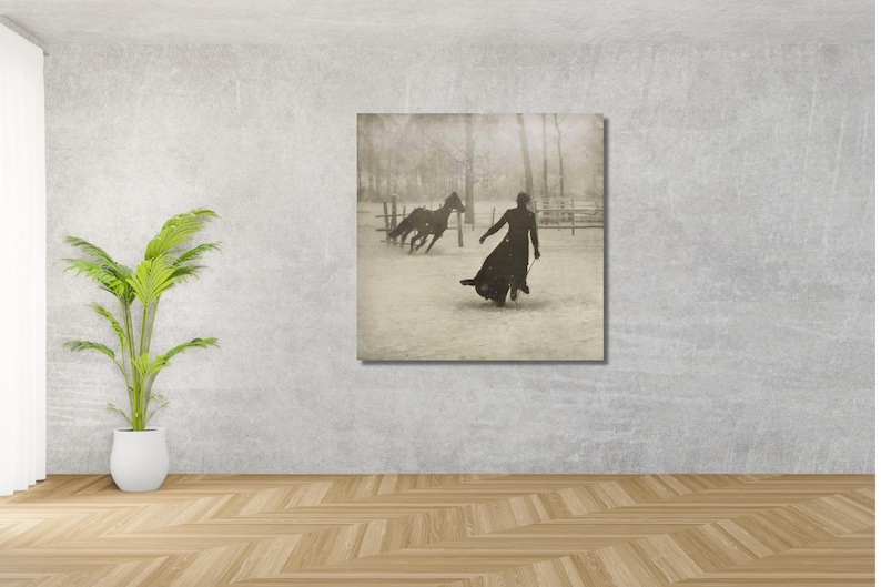 May include: A black and white photograph of a person in a long coat walking away from two horses in a snowy field.
