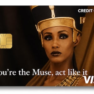 K&ouml;nnte beinhalten: Kreditkarte mit Goldchip und VISA-Logo. Die Karte zeigt eine Frau mit goldener Kopfbedeckung und dem Text "You're the Muse, act like it". Der Hintergrund ist dunkel mit einem goldenen Vorhang.