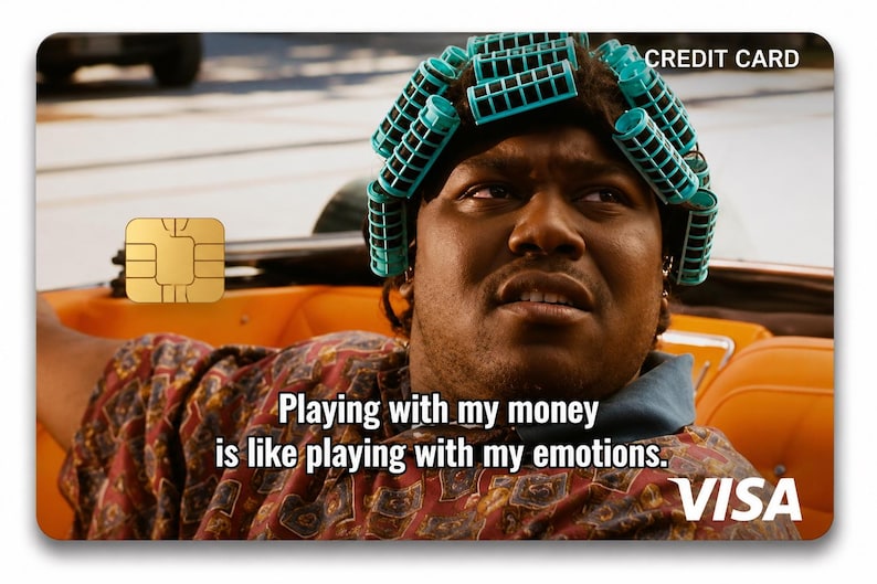 K&ouml;nnte beinhalten: Kreditkartendesign mit einer Person mit t&uuml;rkisfarbenen Lockenwicklern in einem orangefarbenen Auto. Die Karte hat einen goldenen Chip und den Text "Mit meinem Geld zu spielen ist wie mit meinen Emotionen zu spielen." Das Visa-Logo ist sichtbar.
