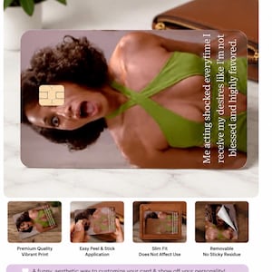 K&ouml;nnte beinhalten: Eine rechteckige Karte mit einer Frau in einem gr&uuml;nen Oberteil mit dem Text "Me acting shocked everytime I receive my desires like I'm not blessed and highly favored." Die Karte hat einen goldenen Chip und wird mit anderen Karten und einer Brieftasche gezeigt.