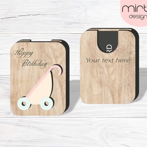 May include: A wooden card with a cutout of a baby stroller and the text "Happy Birthday". The card is designed to be used as a gift card holder and has a slot for a gift card. The back of the card has the text "Your text here".