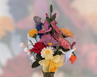 May include: A colorful bouquet of crocheted flowers in a clear glass vase. The arrangement includes red roses, yellow daffodils, purple irises, and other flowers in shades of pink, orange, and blue. The flowers are intricately crafted with detailed stitching.