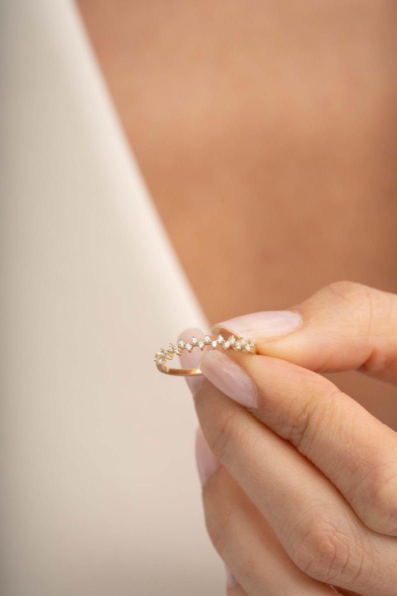 A thin 3mm wide silver ring coated in green gold plating with sparkling clear cubic zirconia stones set around the band.