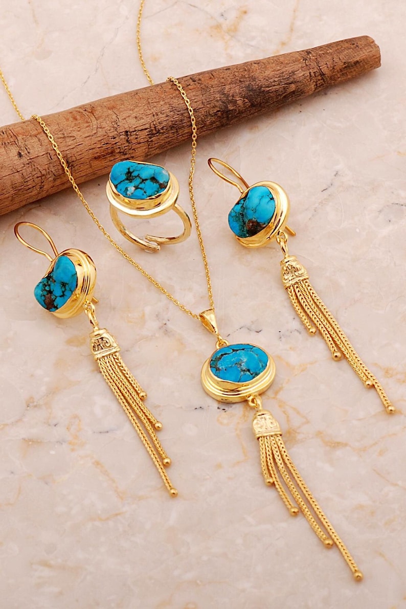 A handmade 925 sterling silver gold plated jewelry set featuring a woven tassel pendant necklace, dangling earrings, and an adjustable ring, all adorned with natural blue turquoise stones.