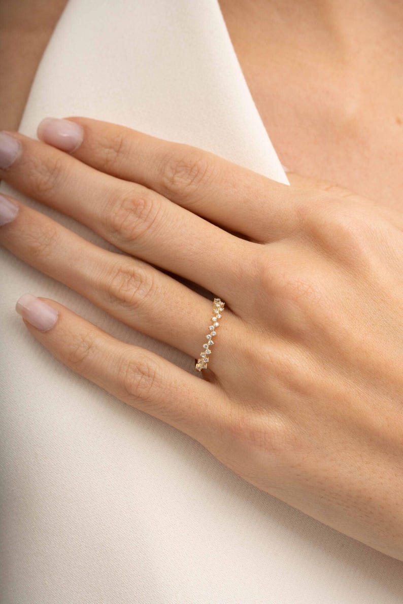 A thin 3mm wide silver ring coated in green gold plating with sparkling clear cubic zirconia stones set around the band.