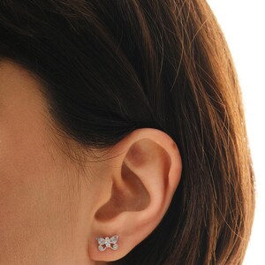 Mini butterfly earrings made of rhodium‑plated sterling silver with a white zircon stone, measuring 6 mm by 9 mm.