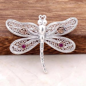 Sterling Silver Dragonfly Brooch with Ruby Colored Stones and Filigree Wings Featuring Rose Accents for Vintage Style Jewelry Lovers