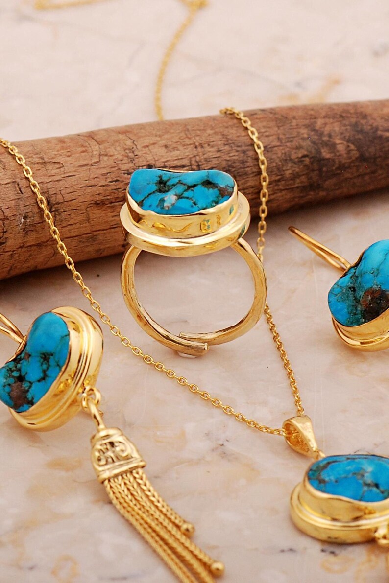 A handmade 925 sterling silver gold plated jewelry set featuring a woven tassel pendant necklace, dangling earrings, and an adjustable ring, all adorned with natural blue turquoise stones.