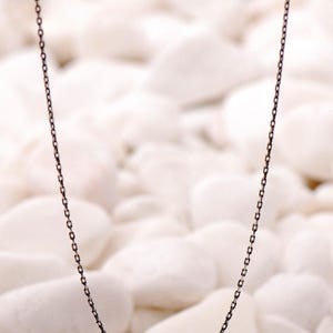 A 45 cm long blackened 925 sterling silver chain necklace with an oxidized finish displayed on a dark background.