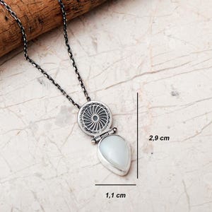Handmade 925 sterling silver teardrop jewelry set featuring a mother of pearl pendant necklace and matching drop earrings adorned with intricate vintage motifs and an oxidized silver finish.