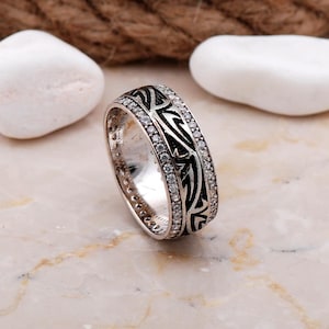 Handmade silver ring with cubic zirconia stones, white gold rhodium plating, and a 7.5 mm wide band.