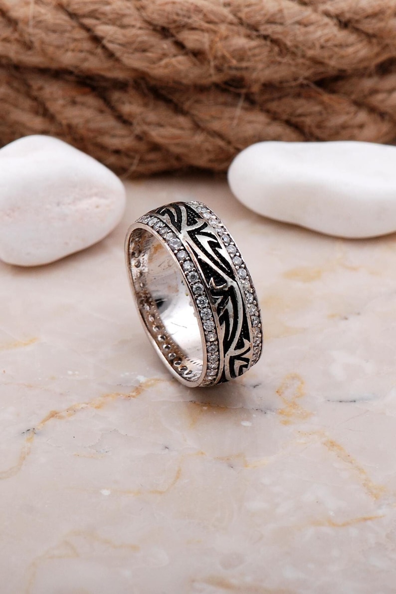 Handmade silver ring with cubic zirconia stones, white gold rhodium plating, and a 7.5 mm wide band.