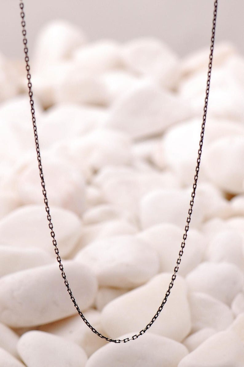 A 50 cm long blackened oxidized silver chain necklace with a sleek 1 mm thickness, displayed on a neutral background.