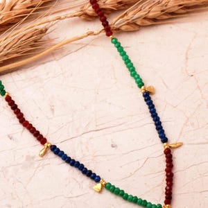 A handcrafted necklace of 925 sterling silver with green gold-plated motifs, featuring ruby, emerald, and sapphire stones along a 36 cm chain with a 4 cm extender.