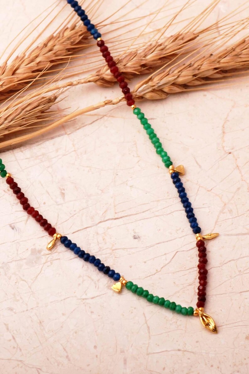 A handcrafted necklace of 925 sterling silver with green gold-plated motifs, featuring ruby, emerald, and sapphire stones along a 36 cm chain with a 4 cm extender.
