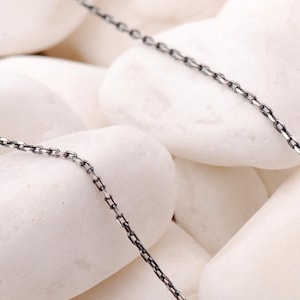 A 50 cm long blackened oxidized silver chain necklace with a sleek 1 mm thickness, displayed on a neutral background.