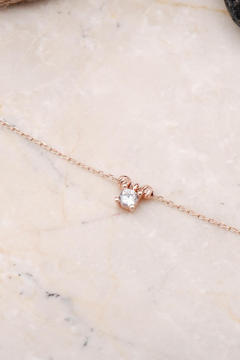 A rose‑gold plated hair coil made of 925 sterling silver, adorned with small cubic zirconia stones, measuring about 23 cm in length.