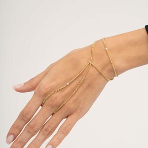 A delicate double-wrap gold-plated 925 sterling silver Sahmeran hand chain with hand-engraved curb chain detailing that sparkles like gemstones.