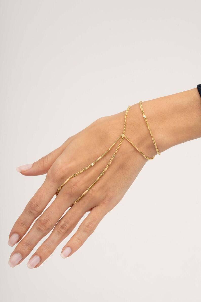 A delicate double-wrap gold-plated 925 sterling silver Sahmeran hand chain with hand-engraved curb chain detailing that sparkles like gemstones.