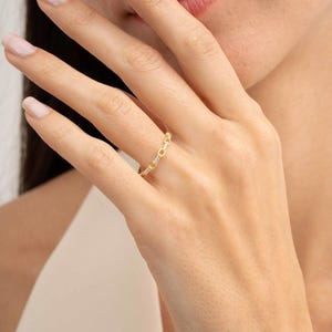 A delicate gold-plated 925 sterling silver chain link band ring encrusted with sparkling clear cubic zirconia stones against a neutral background.