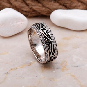 Handmade silver ring with cubic zirconia stones, white gold rhodium plating, and a 7.5 mm wide band.