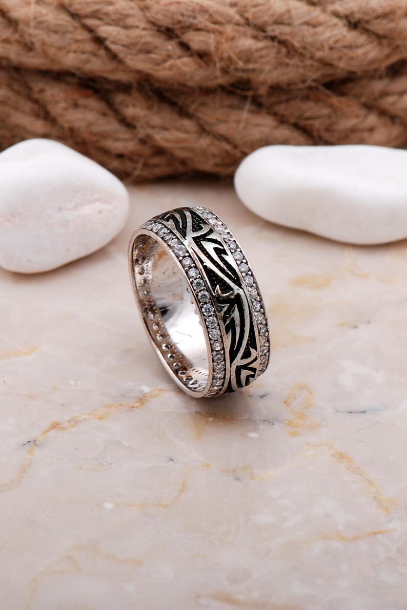 Handmade silver ring with cubic zirconia stones, white gold rhodium plating, and a 7.5 mm wide band.