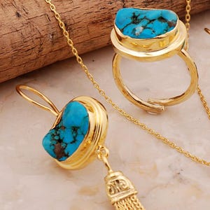 A handmade 925 sterling silver gold plated jewelry set featuring a woven tassel pendant necklace, dangling earrings, and an adjustable ring, all adorned with natural blue turquoise stones.