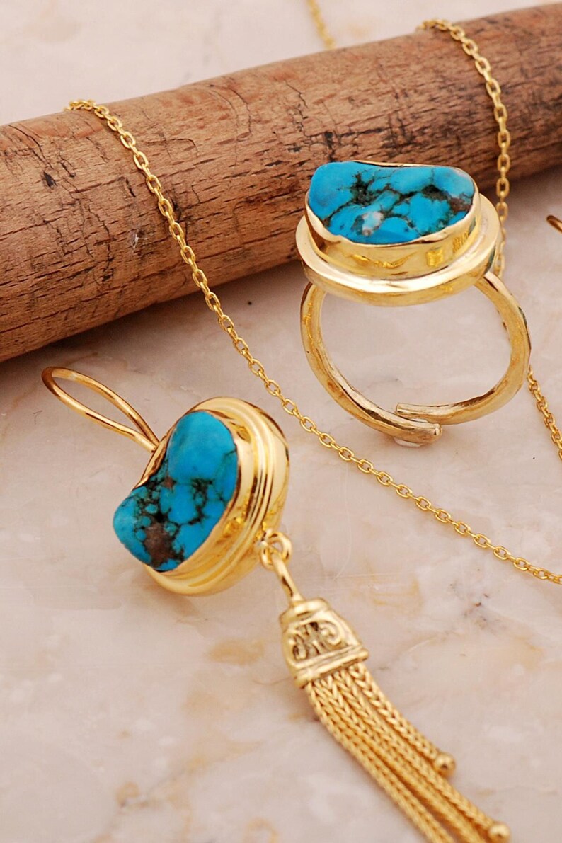 A handmade 925 sterling silver gold plated jewelry set featuring a woven tassel pendant necklace, dangling earrings, and an adjustable ring, all adorned with natural blue turquoise stones.