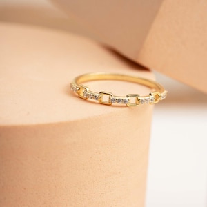 A delicate gold-plated 925 sterling silver chain link band ring encrusted with sparkling clear cubic zirconia stones against a neutral background.