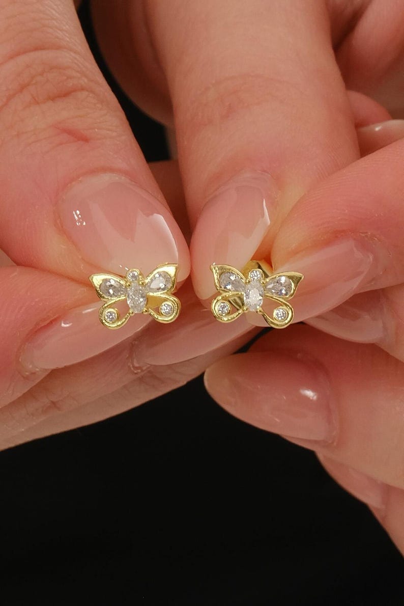 Mini butterfly earrings made of 925 sterling silver with green gold rhodium plating and white zircon stones, measuring 6 mm tall by 9 mm wide.